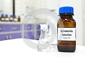 Selective focus of ammonia solution or ammonium hydroxide in glass amber bottle inside a chemistry laboratory with copy space.