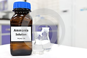 Selective focus of ammonia solution or ammonium hydroxide in glass amber bottle inside a chemistry laboratory with copy space.