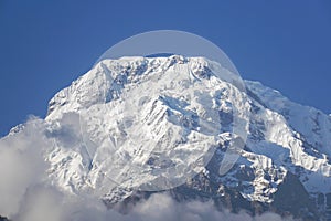 selective focus Annapurna mountain peak with thick white snow on top and bright sunshine in winter season