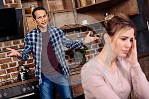 selective focus of argued couple in kitchen at home relationship photo