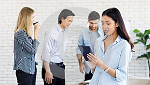 Selective focus on Asian businesswomen using a tablet computer to meet with business people Ethnic diversity in the office