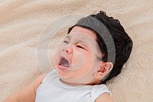 Selective focus Asian newborn baby crying after wake up in morning, adorable infant unhappy feel uncomfortable or hungry, toddler