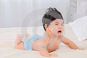 Selective focus Asian newborn baby crying after wake up in morning, adorable infant unhappy feel uncomfortable or hungry, toddler