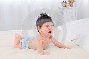 Selective focus Asian newborn baby crying after wake up in morning, adorable infant unhappy feel uncomfortable or hungry, toddler