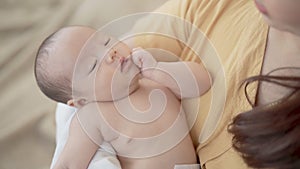 Selective focus Asian toddler newborn sleep in mother arm embracing gentle, comfortable, safe. Close up Mom hold infant with love,