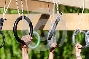 selective focus, athletes hands at a hanging obstacle at an obstacle course race, OCR