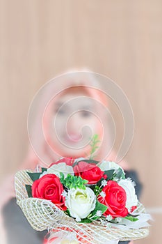 Selective focus of attractive young Arabian business woman holding flower bouquet