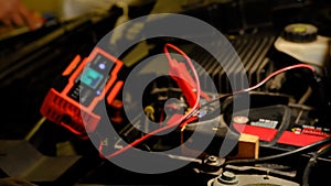 Selective focus an auto mechanic uses a multimeter voltmeter to check the voltage level in a car battery. Man use