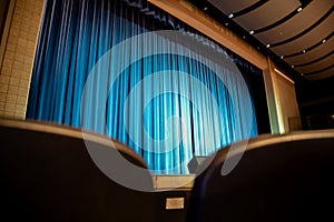 selective focus on the back of a audience chair at a community theater stage.