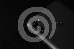 Selective focus on back of new smartphone Samsung Galaxy M11 triple camera and fingerprint sensor. Bucharest, Romania, 2021
