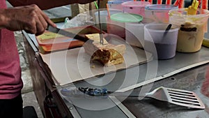 Selective focus. a baker is slicing with a knife.