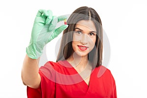 Selective focus of beautiful nurse wearing scrubs showing one pill