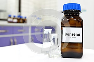 Selective focus of benzene liquid chemical compound in dark glass bottle inside a chemistry laboratory with copy space. photo