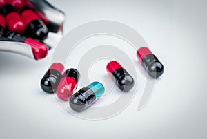 Selective focus blue-green capsule pill and drug tray with red-black capsule. Global healthcare. Antibiotics drug resistance.