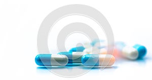 Selective focus on blue and white capsules pill spread on white background with shadow. Global healthcare concept. Antibiotics photo