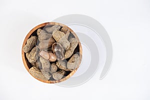 selective focus on boiled peanuts on wooden bowl isolated on white background