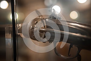 Selective focus, bokeh. background with old weapons. Revolver of old modification, close up, details of a firearm