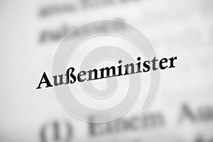 Selective focus from the book page of the word 'Aubenminister' translated as foreign minister