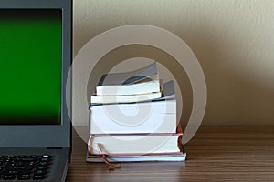 Selective focus of books stacked on work desk with the computer, Back to school concept or business work concept image