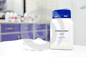 Selective focus of a bottle of ethylparaben paraben pure chemical compound used as food additive preservative White laboratory bac