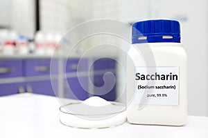 Selective focus of a bottle of pure sodium saccharin artificial sweetener sugar substitute. White laboratory background with copy