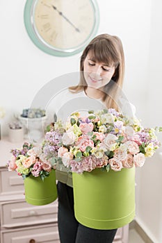 Selective focus on bouquet in green hatbox. beautiful luxury bunch of mixed flowers in womans hand. the work of the
