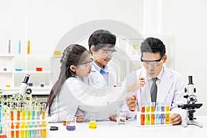 Selective focus at boy face. Young Asian boy and girl study science class using Microscope and chemical liquid to do the
