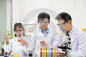 Selective focus at boy face. Young Asian boy and girl study science class using Microscope and chemical liquid to do the