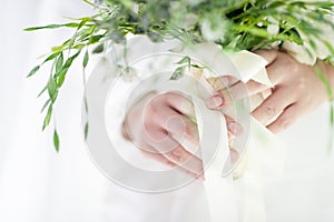 Selective focus the bride`s hand holding the wedding bouquet White and green tones. The elegant simplicity of the happy day