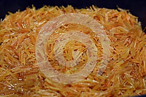 Selective focus of Browned in Butter sweet Egyptian vermicelli cooked with water and sugar in a cooking pot,.