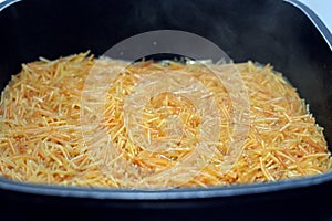 Selective focus of Browned in Butter sweet Egyptian vermicelli cooked with water and sugar in a cooking pot,.