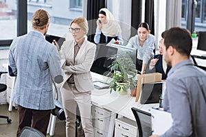 selective focus of businesspeople having discussion and colleagues working near