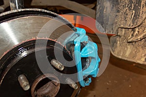 Selective focus of car brake disc for repair. Repair of car brakes in the garage.