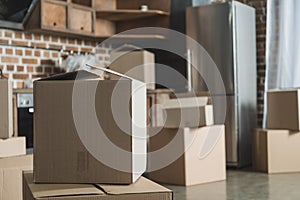 selective focus of cardboard boxes in empty kitchen during relocation