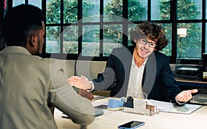 Selective focus Caucasian businessman seriously discussing with colleague, argument, disputing while sitting in modern meeting