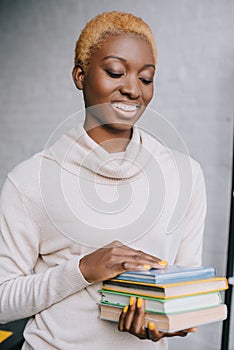 Selective focus of cheerful african american woman holding books