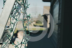 Selective focus on Christmas lights hanging off a ladder rung