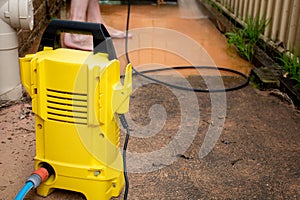 Selective focus. Cleaning backyard paving tiles with high pressure washer