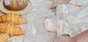 Selective focus and close up on hands using rolling pin to teach and thresh dough flour to make pie and bread for serving on table