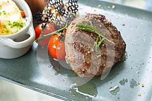 Selective focus and close up shot of well prepared beef juicy steak with luxury decoration of mash potato, sauce and tomatoes