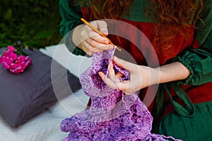 Selective focus. Close-up of women`s hands knitting a shawl