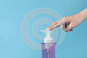 Selective focus closeup of a hand touching the sanitizer bottle-concept COVID19 prevention