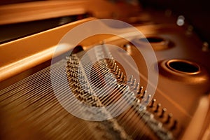 Selective focus closeup view on hammers and strings inside grand piano