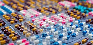 Selective focus on colorful antibiotic capsule pills in blister pack. Antibiotic drug resistance. Pharmaceutical industry.
