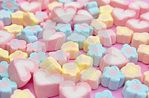 Selective focus colorful fluffy marshmallows on pink background, sweet dessert fudge