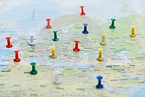 Selective focus of colorful push pins on world map.