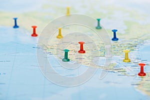 Selective focus of colorful push pins on world map with copy space.