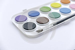 Selective focus of colorful watercolor palette with brush on white background
