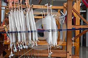 Selective focus of cotton thread on weaver machine. Thai cotton handmade. Homespun fabric process. The process of fabric weaving