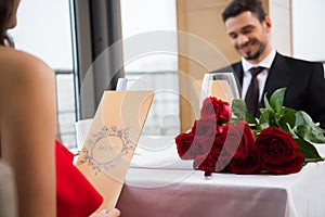 selective focus of couple reading menu on romantic date in restaurant on st